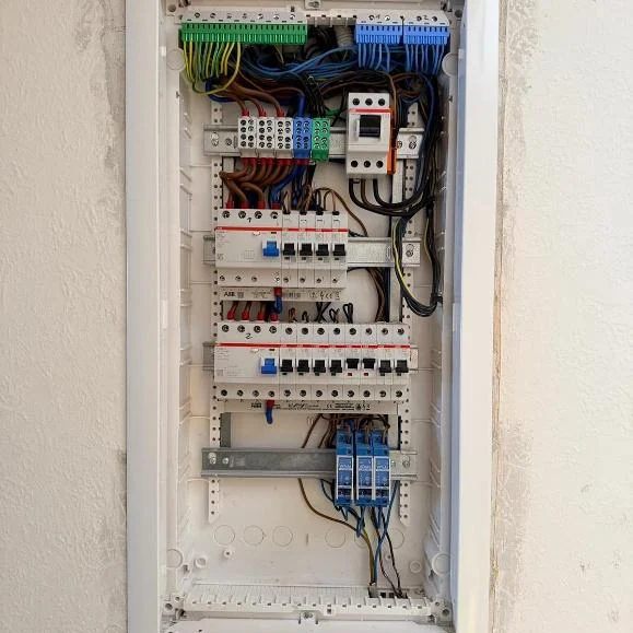 Unterputzverteiler in einer verputzten Bestandswand, geöffnet, mit verdrahteten Sicherungsautomaten